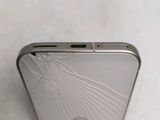 the back of a cell phone with a broken screen sitting on a table