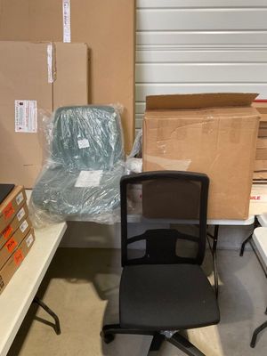a black office chair sitting in front of a stack of boxes