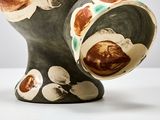 a black vase with a brown and white design on it