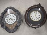 deux horloges posées par terre l'une à côté de l'autre