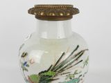 a white vase with a bird on it on a table