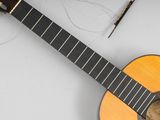 a guitar sitting on a table next to a pen and pencil