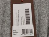 un gros plan sur un pull gris muni d'une étiquette