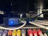 a bunch of cables connected to a computer on a shelf