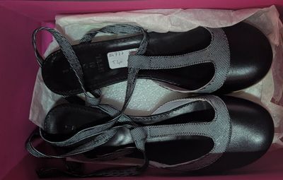 deux paires de chaussures noires dans une boîte rose