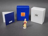 a small figurine of a woman standing next to a box