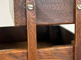 a close up of a wooden chair with leather straps on it