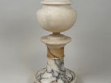 a white marble pedestal with a lid on top of it
