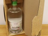 a bottle of gin in a cardboard box on a table