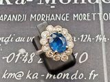 une bague sertie d'une pierre bleue, posée sur un morceau de papier