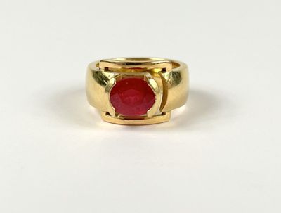 a close up of a gold ring with a red stone in it