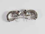 pair of silver metal earrings with spikes on a white surface