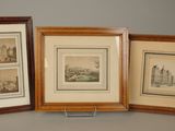 three framed pictures of a city and a cityscape on a table