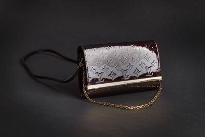 sac à main marron et blanc muni d'une chaîne, sur fond noir