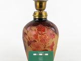 a glass bottle with a floral design on it