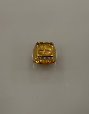 une image d'un anneau en or sur une surface blanche