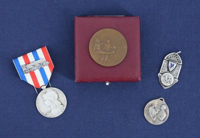 trois médailles et une médaille posée sur une surface bleue