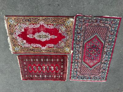 three oriental rugs laid out on the floor in a row