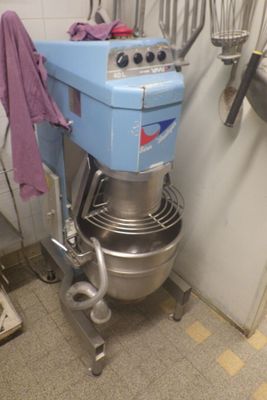 a blue mixer in a kitchen with a purple towel hanging from it ' s handle