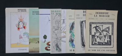 Quatre livres sont alignés sur une table devant un fond noir.