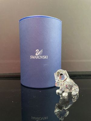 une figurine en cristal posée sur une table à côté d'une boîte bleue