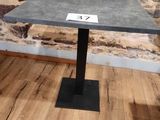 a small table with a number on it in front of a stone wall