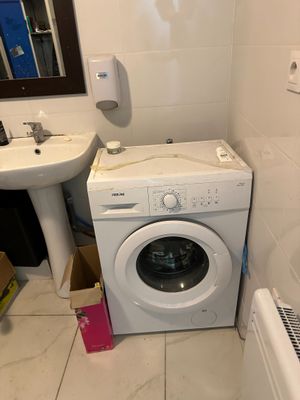 a washer and a toilet in a small bathroom
