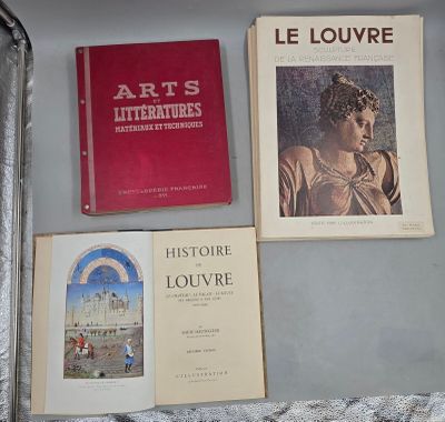 trois livres posés sur une table à côté d'une valise