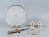 un plateau en argent avec un couteau et d'autres objets posés sur une table