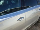 a silver car parked in a parking lot with other cars