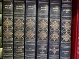 books are lined up in a row on a shelf in a library