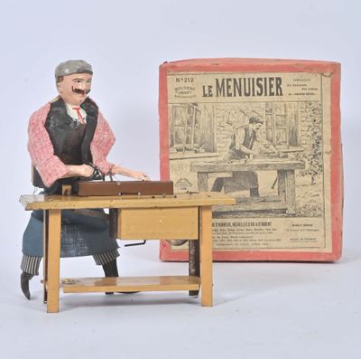 a figurine of a man sitting at a desk in front of a newspaper