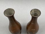 two brown vases sitting next to each other on a table