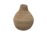 un vase tressé posé sur une surface blanche