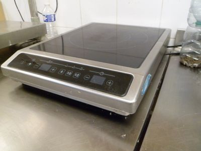 une plaque de cuisson argentée sur laquelle se trouve un brûleur noir