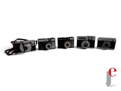 four cameras sitting next to each other on a white surface