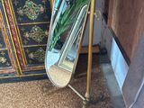 a mirror that is sitting on a stand next to a cabinet