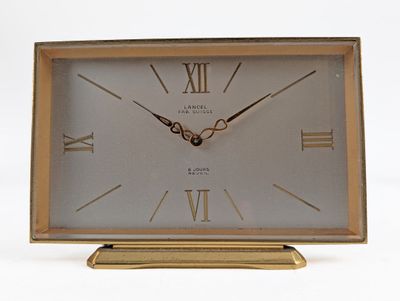 a gold clock with roman numerals on the face