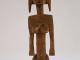 une vieille statue en bois représentant un homme avec un oiseau sur la tête