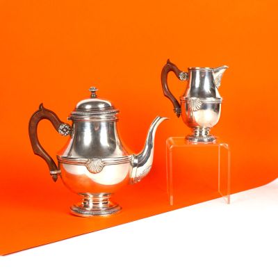 deux théières en argent posées sur un socle transparent