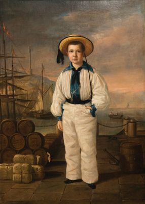 portrait of a boy in a sailor ' s outfit standing on a dock