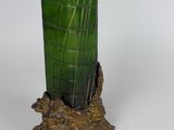 a green vase sitting on top of a tree stump