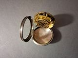 a small gold pocket watch sitting on top of a table