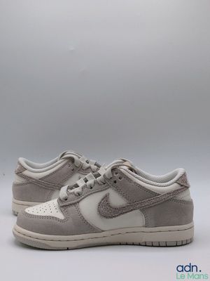 La Nike Dunk Low est une chaussure en daim gris clair dotée d'une semelle blanche.