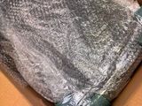 a cardboard box with a blanket wrapped in plastic wrap