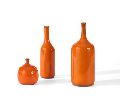 three orange vases sitting next to each other on a white surface