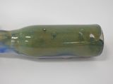 a green and blue bottle that is sitting on a table