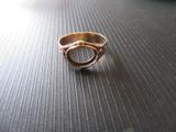 une bague en or posée sur une table, sur fond noir