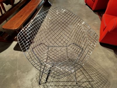 une chaise en fil de fer posée au milieu d'une pièce