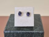 un gros plan sur une paire de boucles d'oreilles en saphir bleu posées sur un bloc de marbre